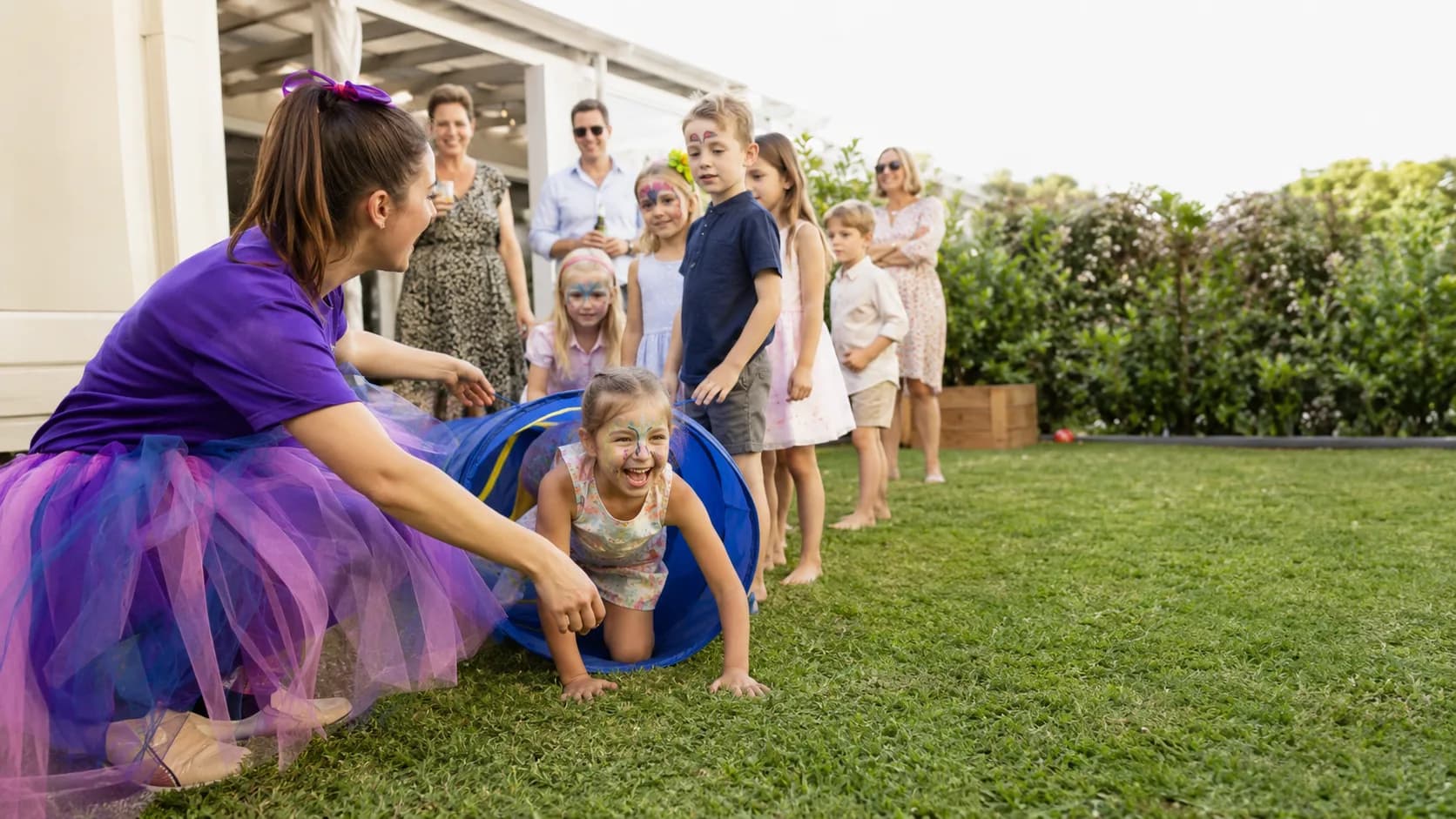 Children laughing at a backyard birthday party on a sunny afternoon
