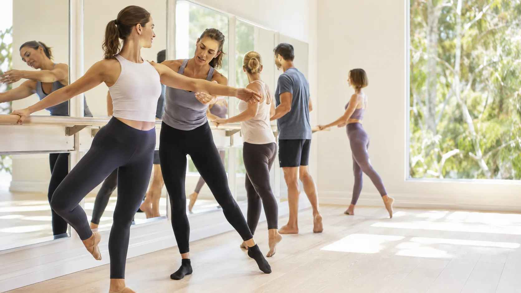Instructor leading an active barre class in a bright Australian studio
