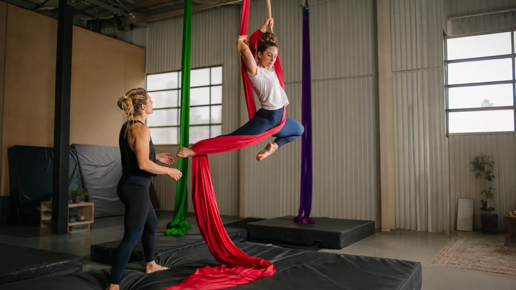 Circus coach supervising an aerial silks class in an Australian training hall