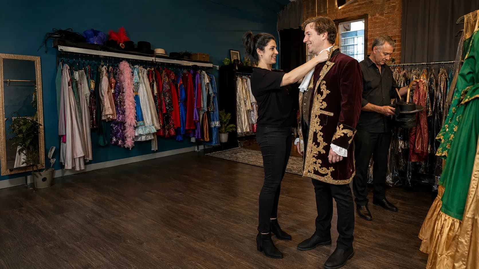 Assistant fitting a period costume inside an hire shop in Australia