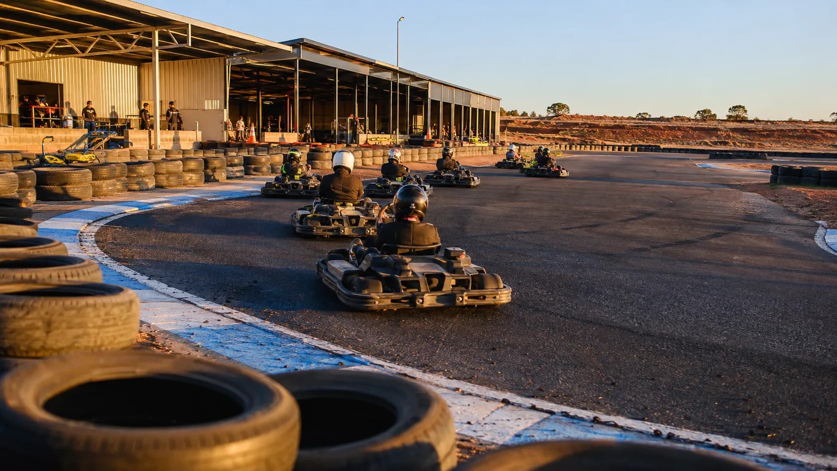 Drivers race outdoor go-karts around a sunlit circuit in Australia