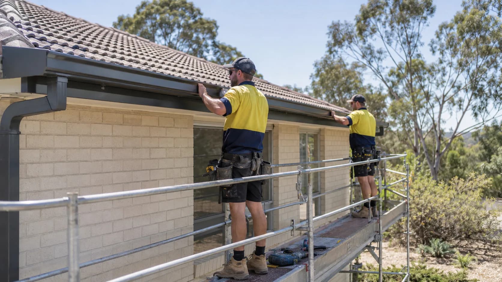 A fitter hanging a new gutter run in Australia