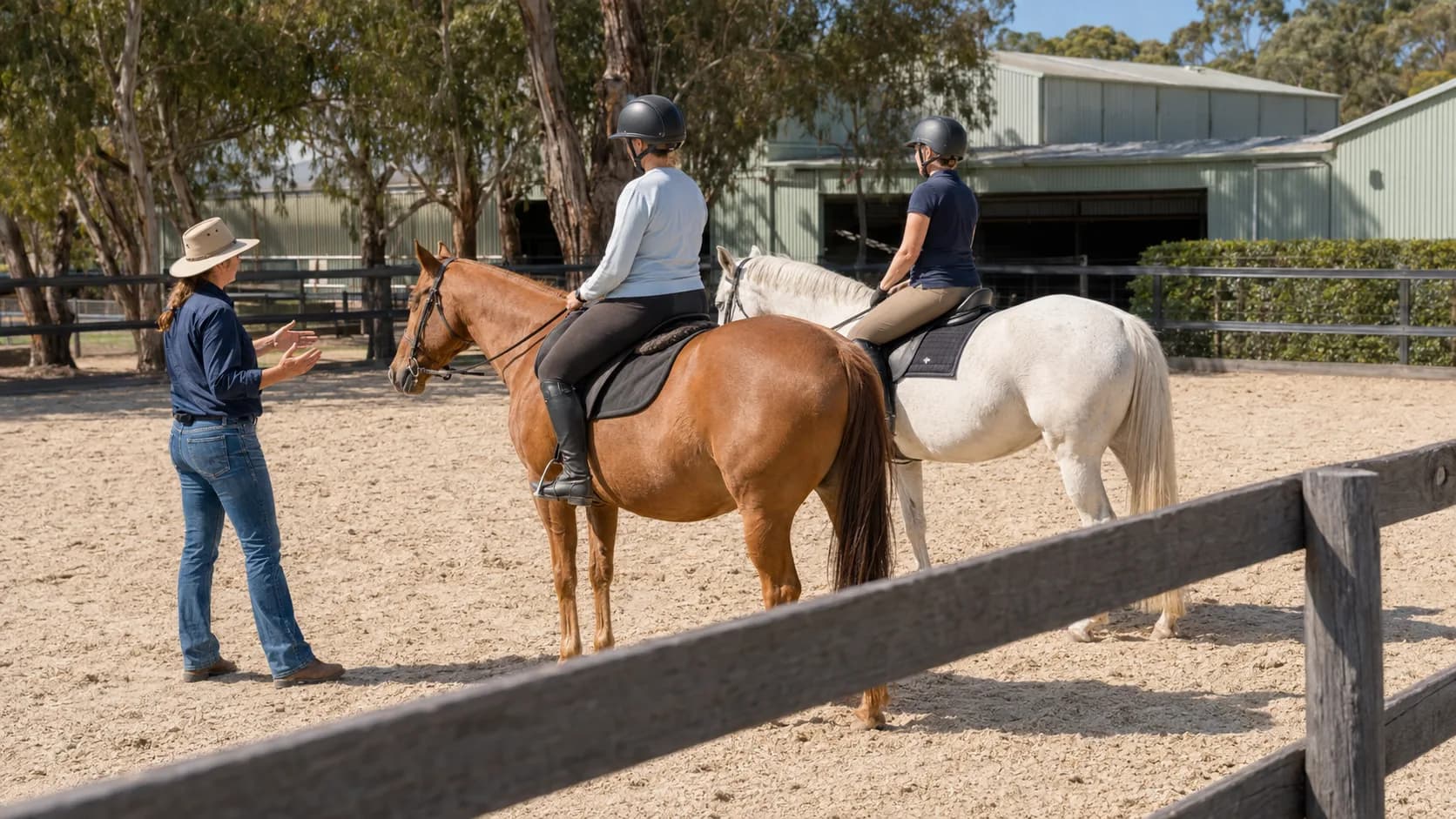 Instructor coaching riders in an outdoor arena at an Australian riding school