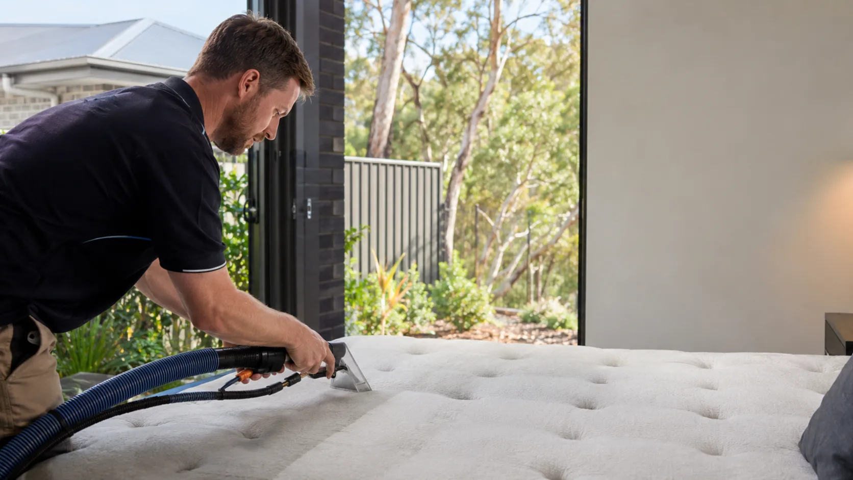 A technician deep-cleaning a mattress in a home in Australia