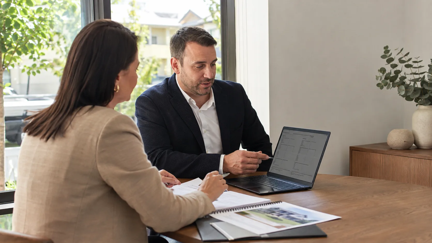 A mortgage broker compares lending scenarios with a buyer in Australia
