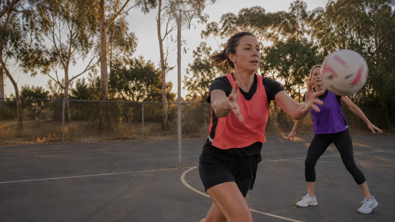 Outdoor netball courts at an Australian community stadium, lined and lit for evening hire
