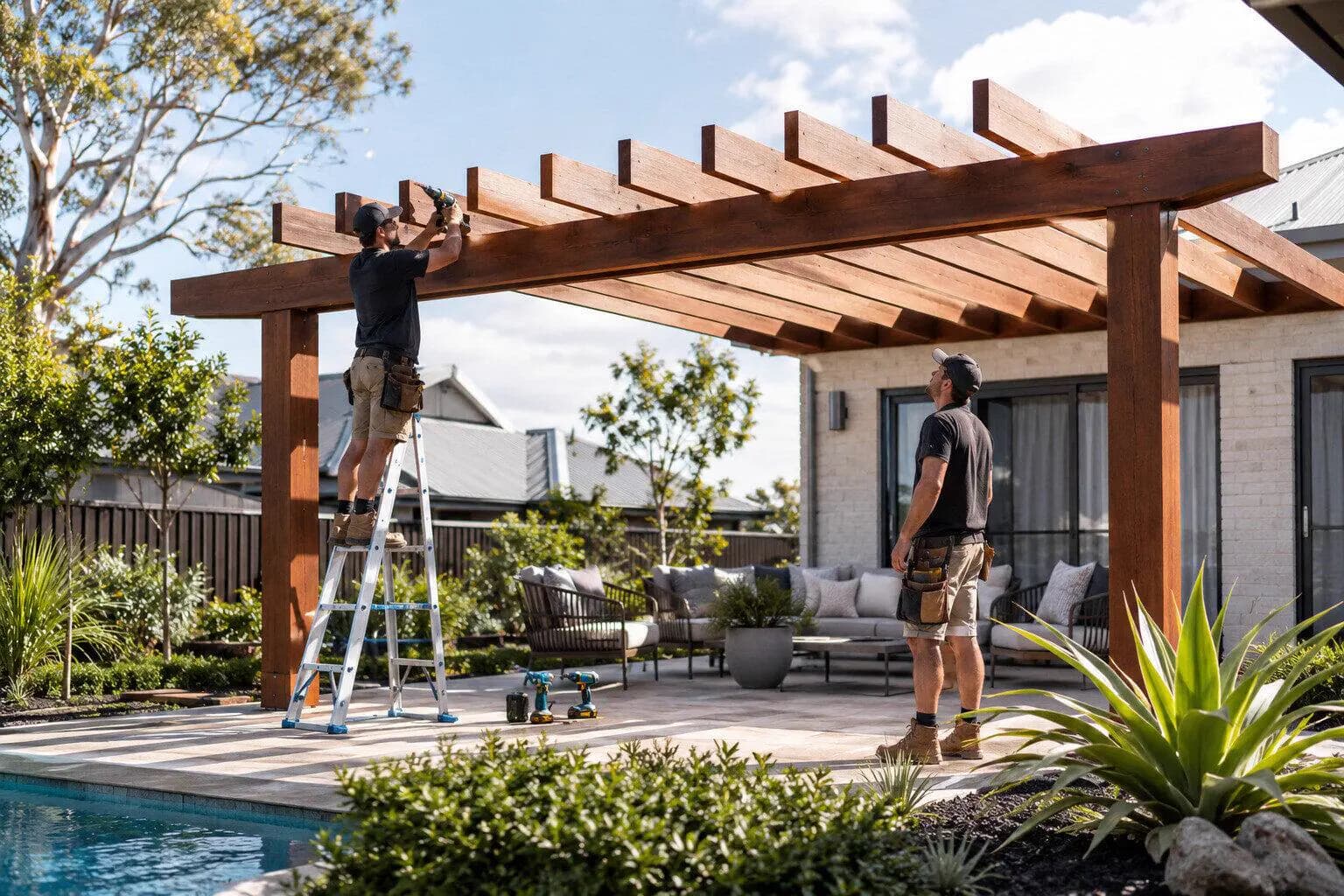 A builder fixing a pergola beam to a house wall in Australia