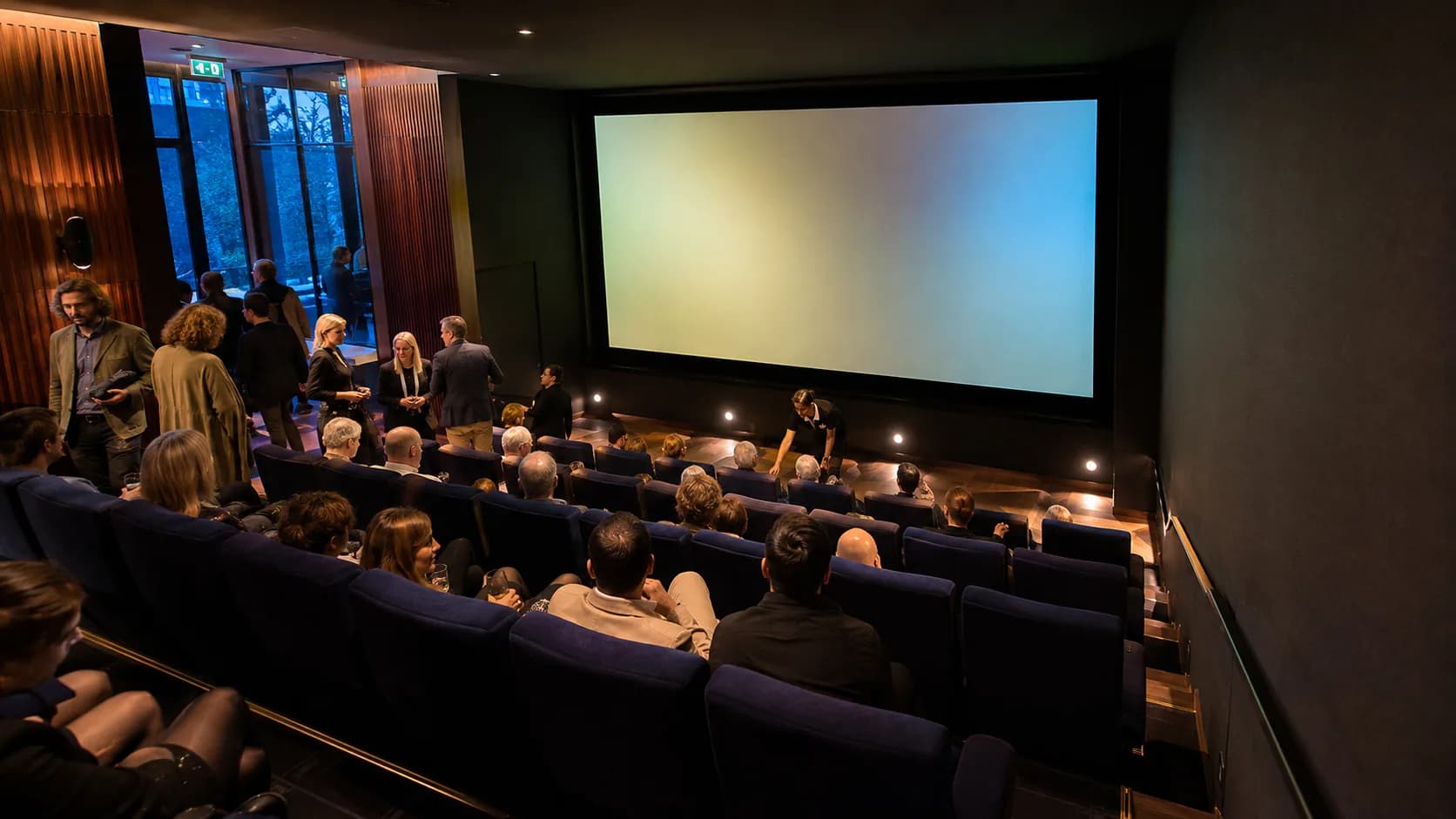 Guests settle into a private screening room under warm cinema lights