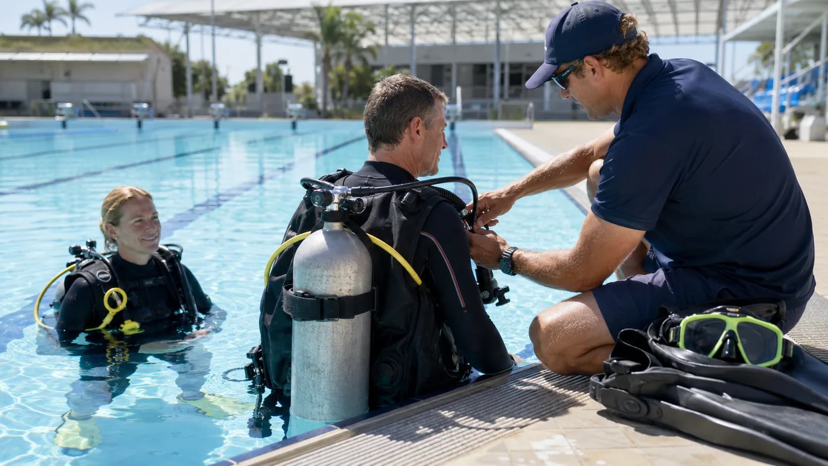 A dive instructor checks scuba equipment beside a training pool in Australia