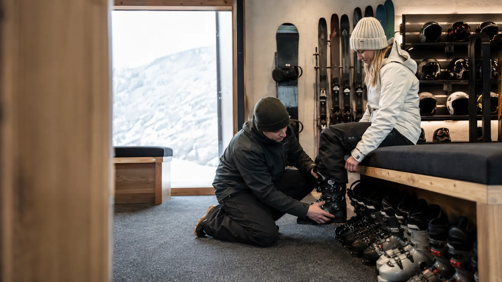 Technician fitting ski boots inside an alpine hire shop in Australia