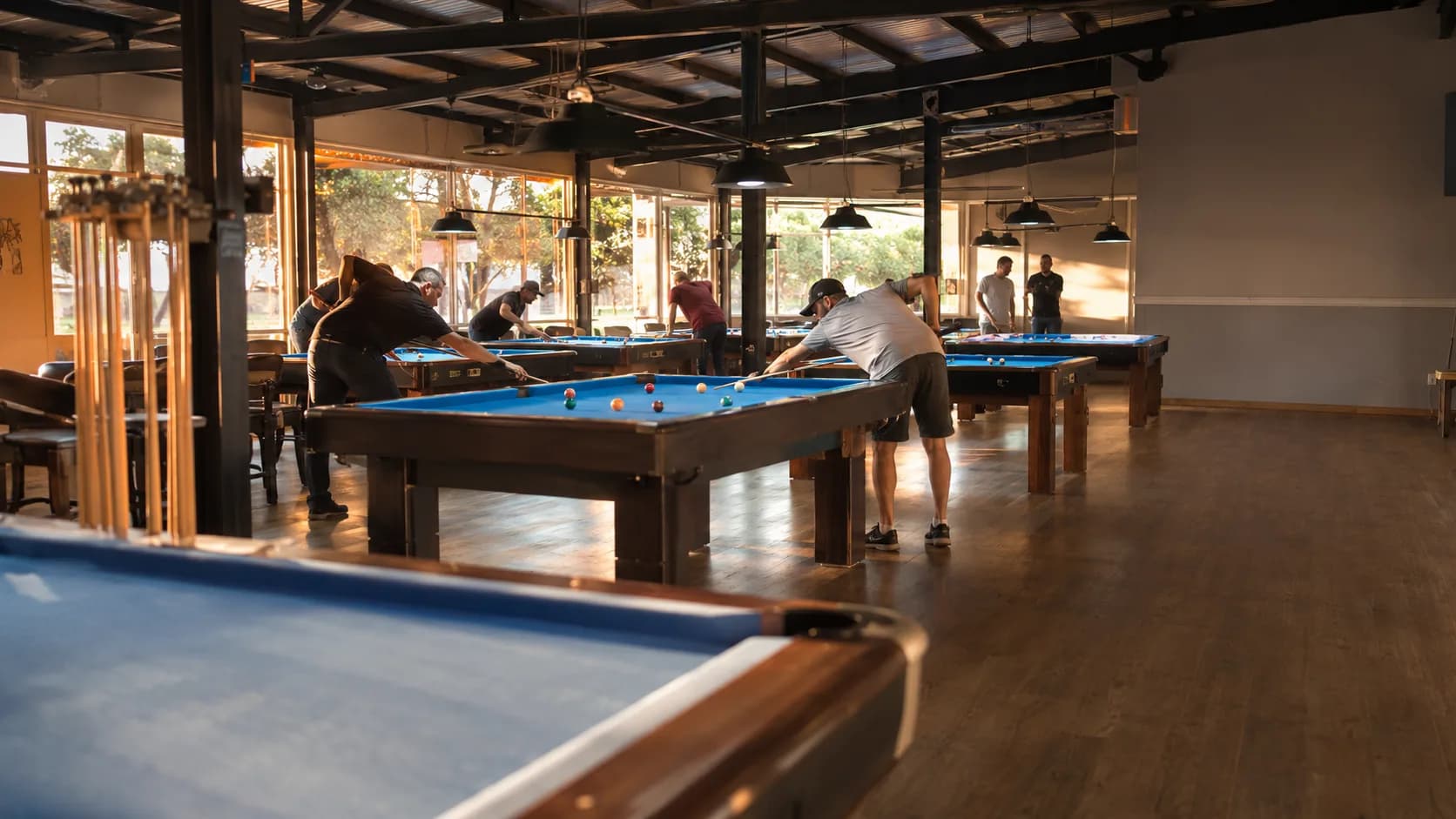 Players line up shots across busy pool tables in an Australian club