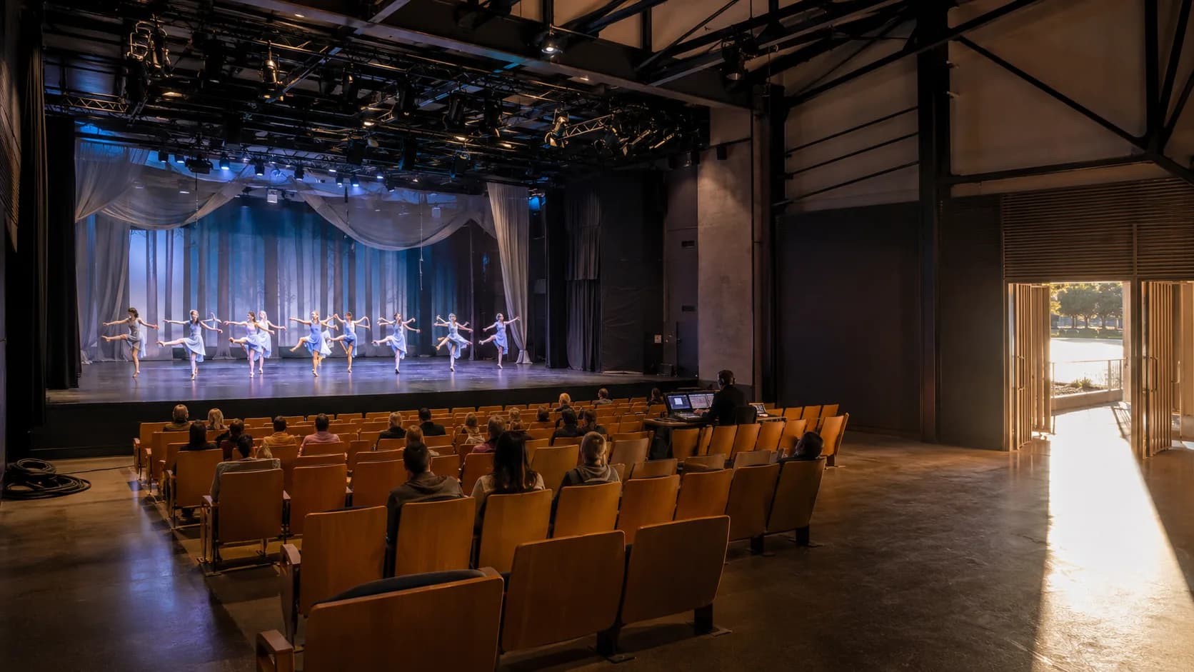 A production crew prepares a warmly lit stage before an audience arrives