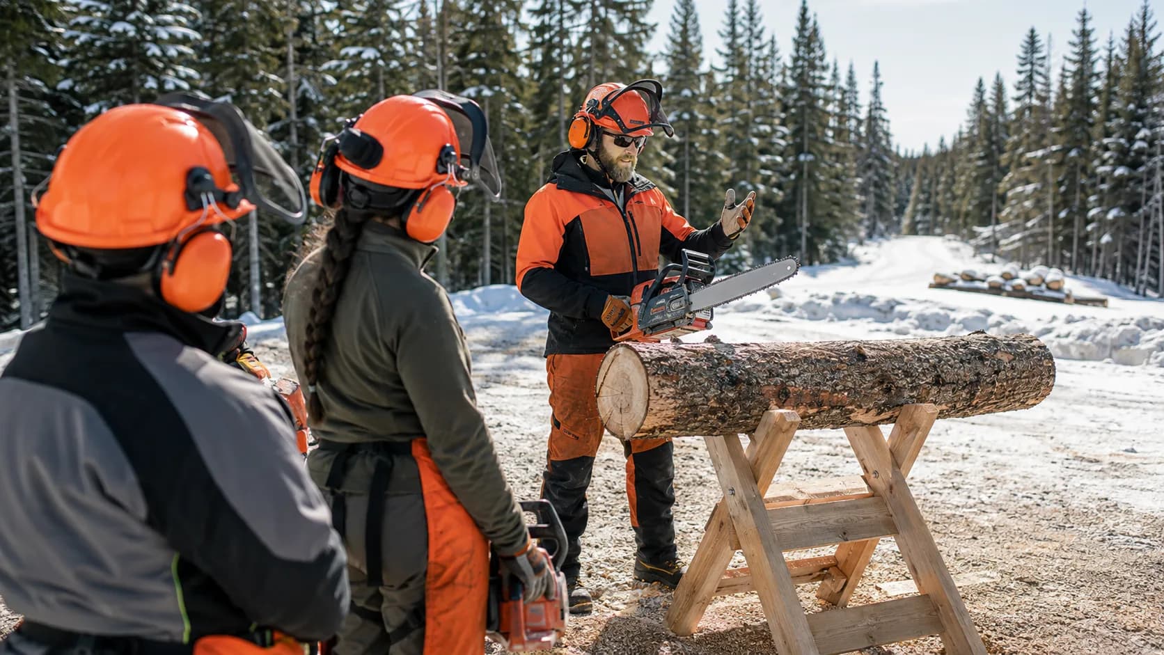 Trainer checks protective equipment beside a supervised chainsaw practice station in Canada