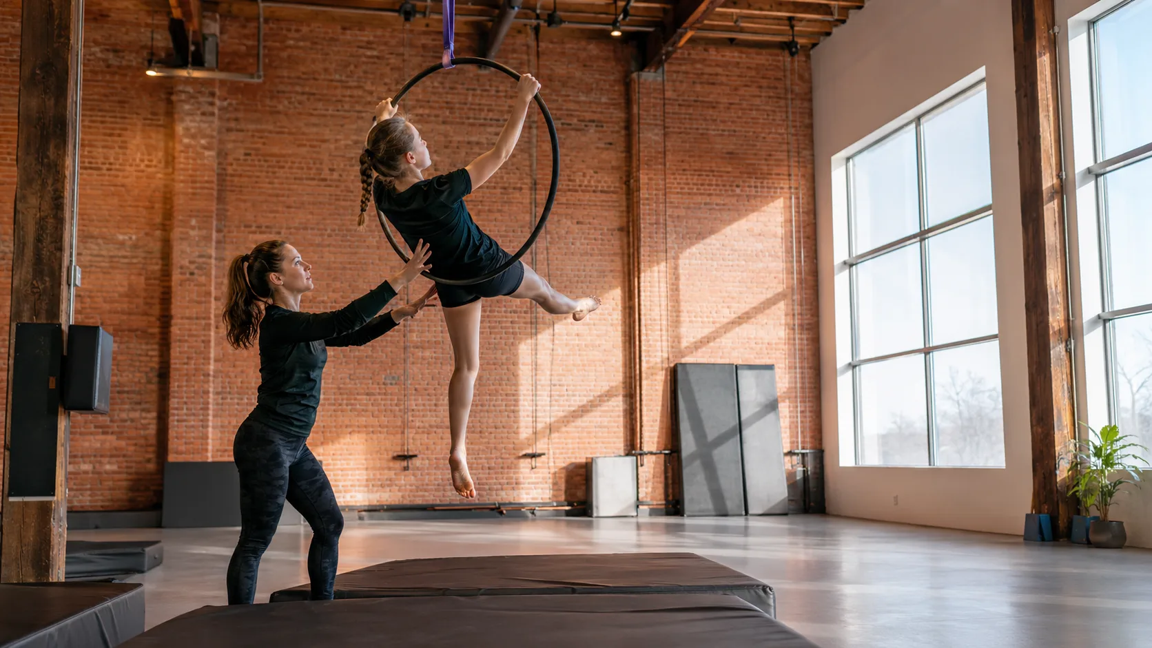 Circus students practising supervised aerial skills in a heated studio in Canada