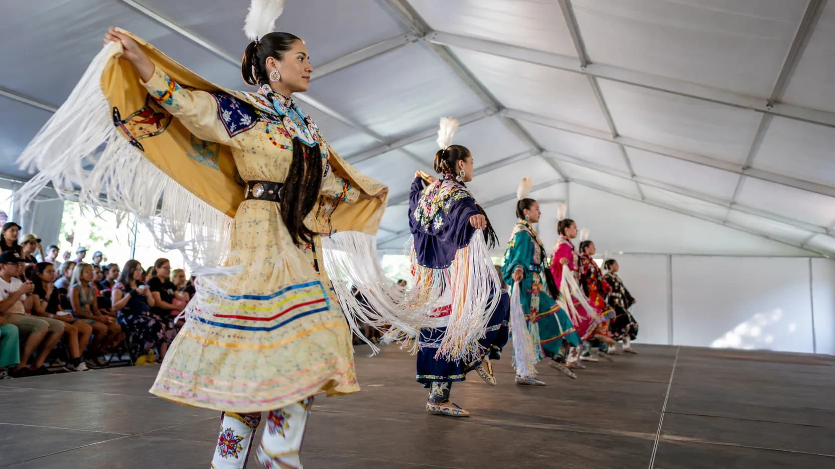 Dance troupe performing for a gathered event audience in Canada