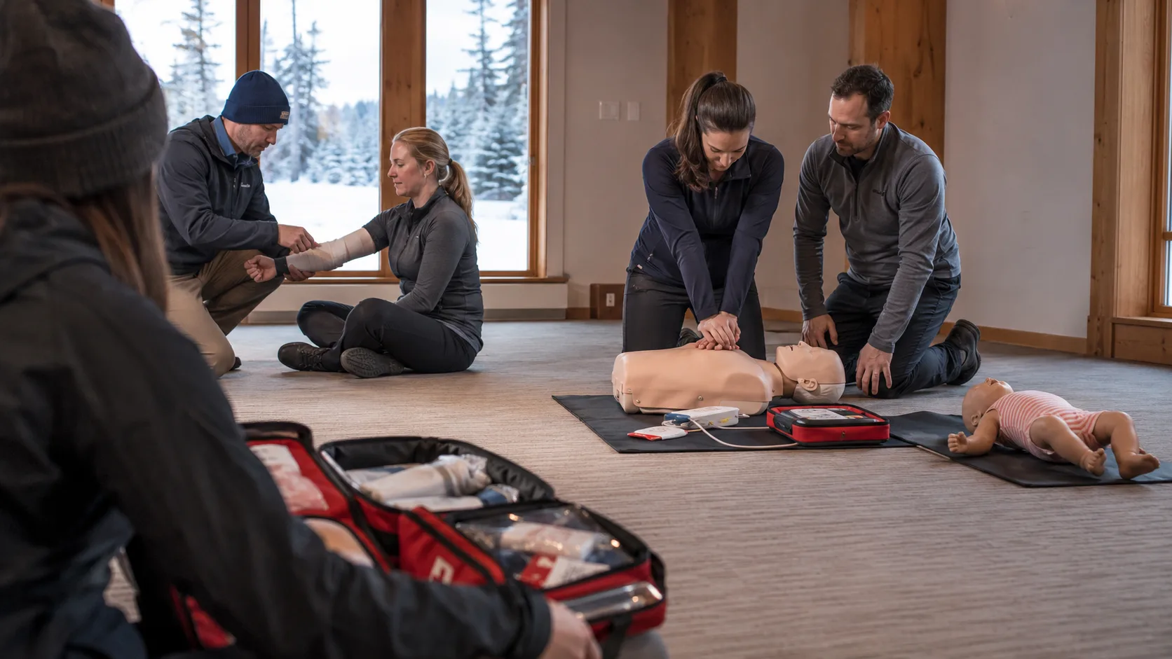 A trainer demonstrates practical first aid to an engaged adult class in Canada