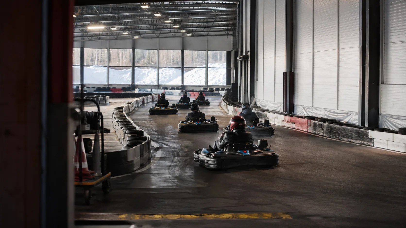 Karts race inside a bright insulated indoor circuit in Canada