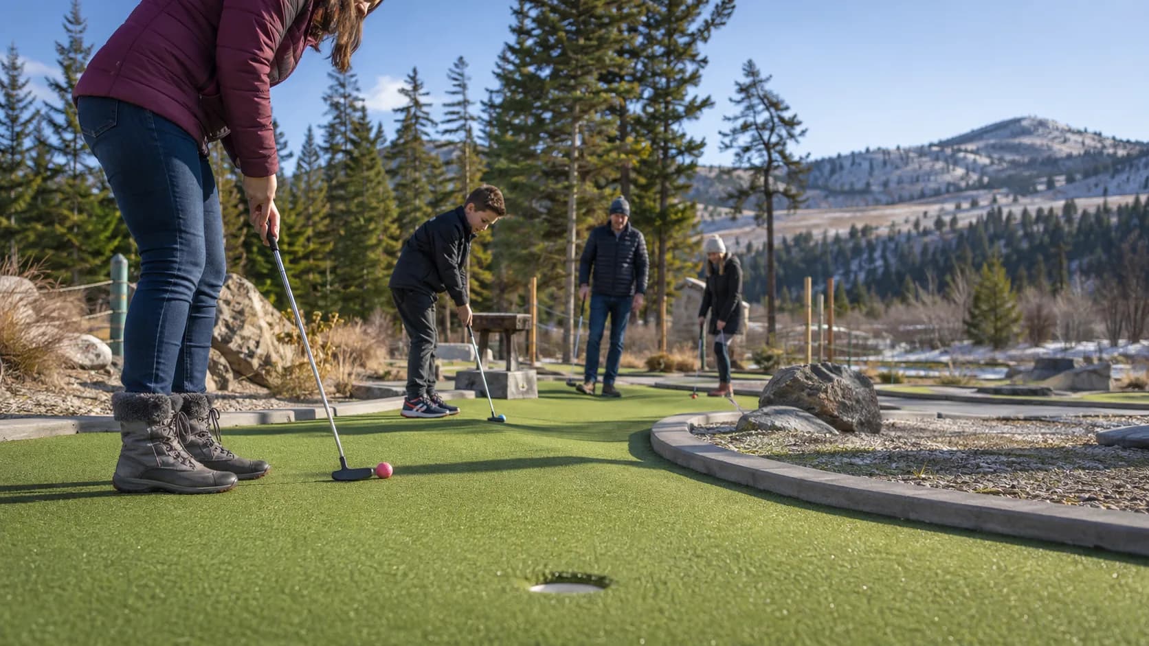 Families play a landscaped mini golf course at a Canadian lakeside park