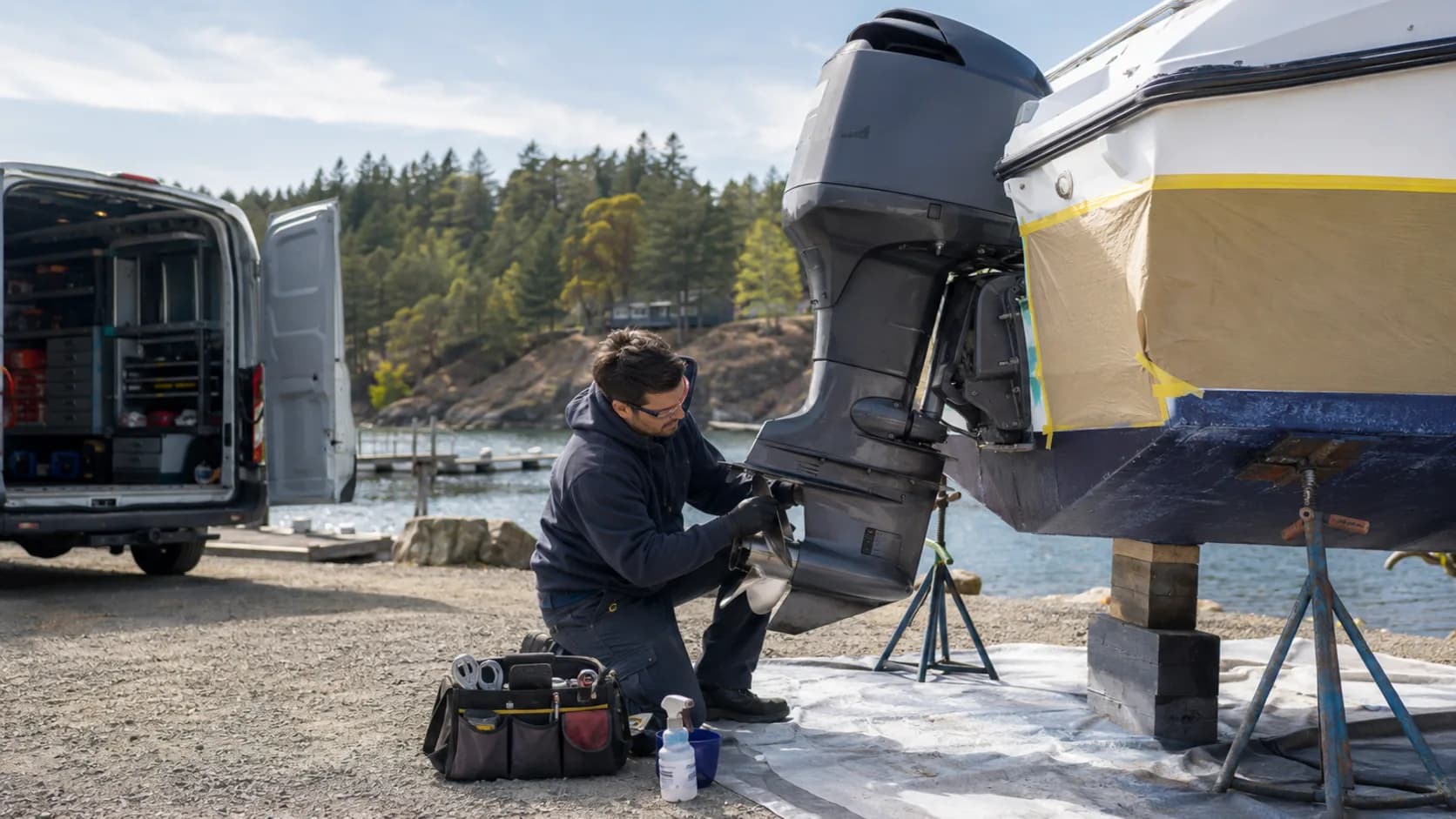 A marine mechanic servicing an engine at a marina berth in Canada