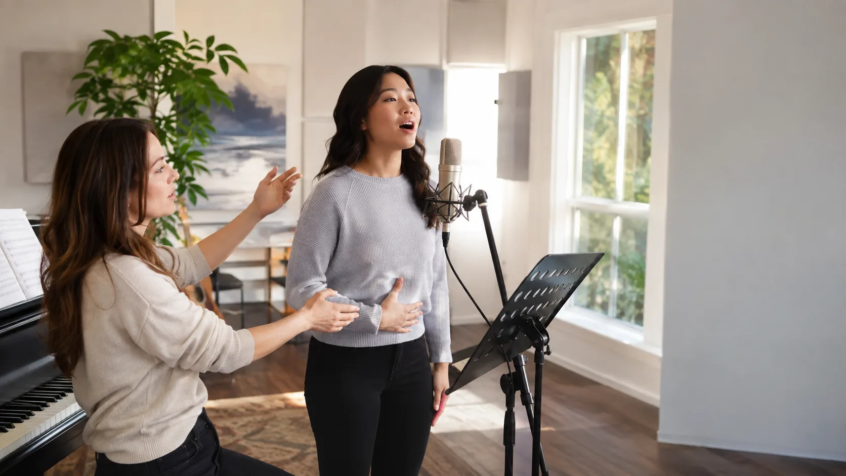 Singing teacher guiding a student in a bright vocal studio in Canada
