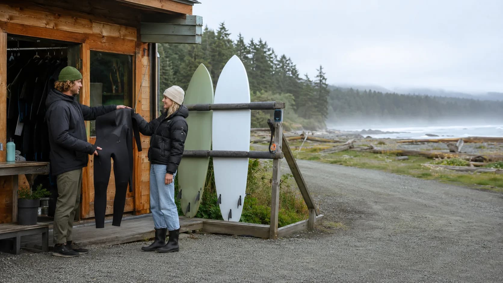 Operator handing over cold-water surf gear beside a beach in Canada