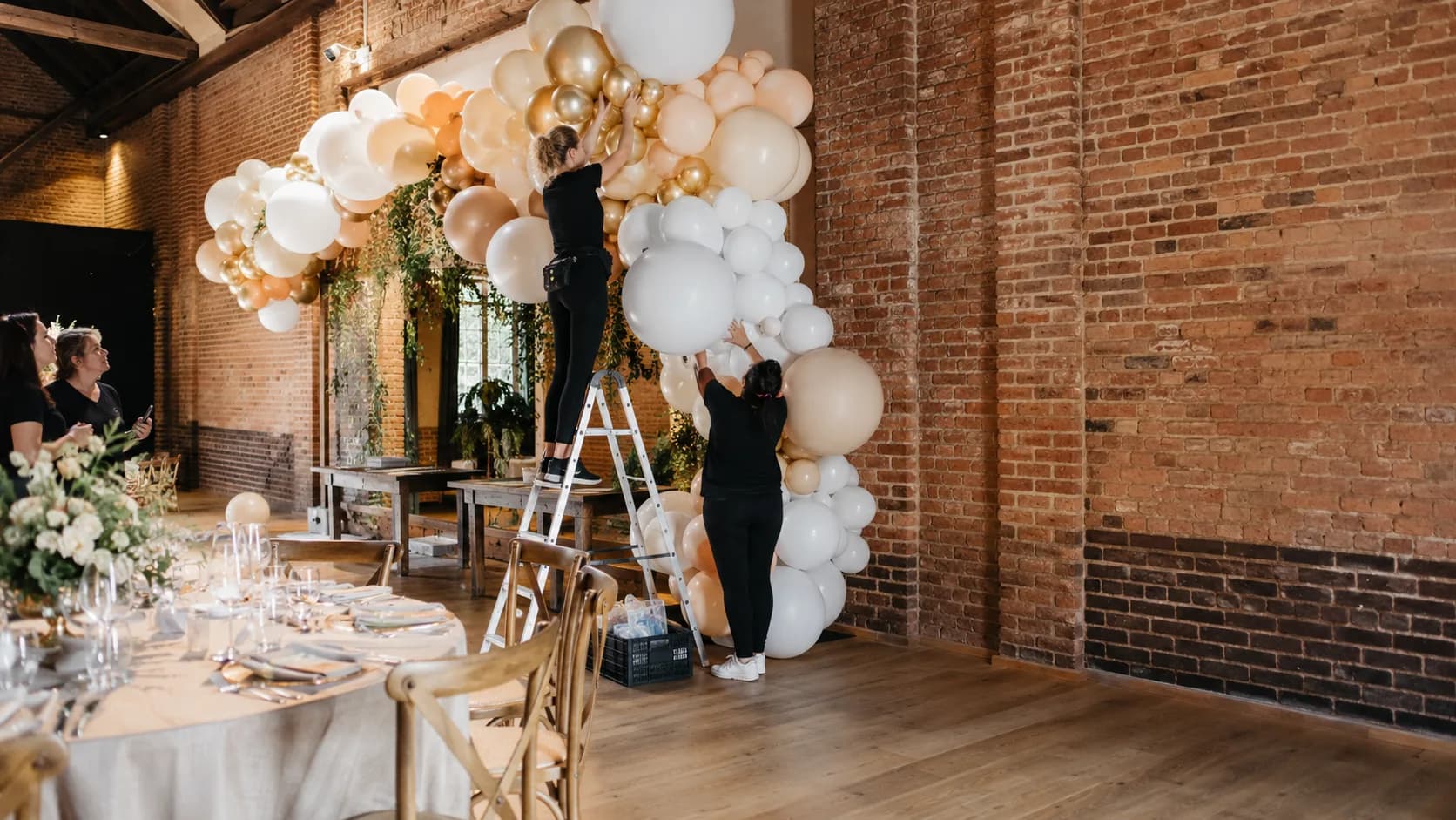 Balloon stylist installing colourful event decor for a booked celebration in the UK