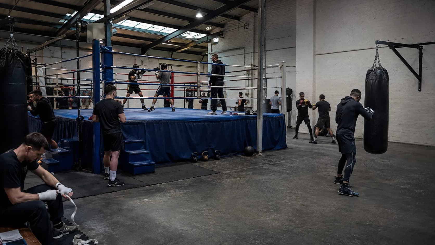 Boxers train around a full-size ring inside a brick gym in the UK