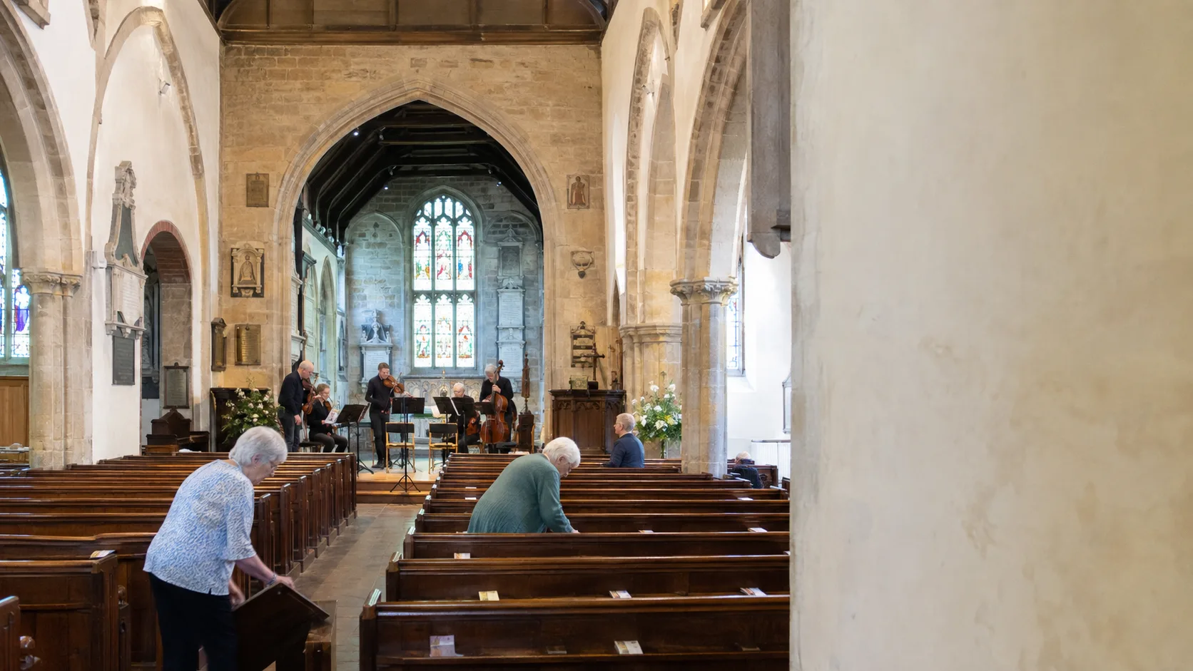 Musicians rehearse in a traditional church under evening lights tonight