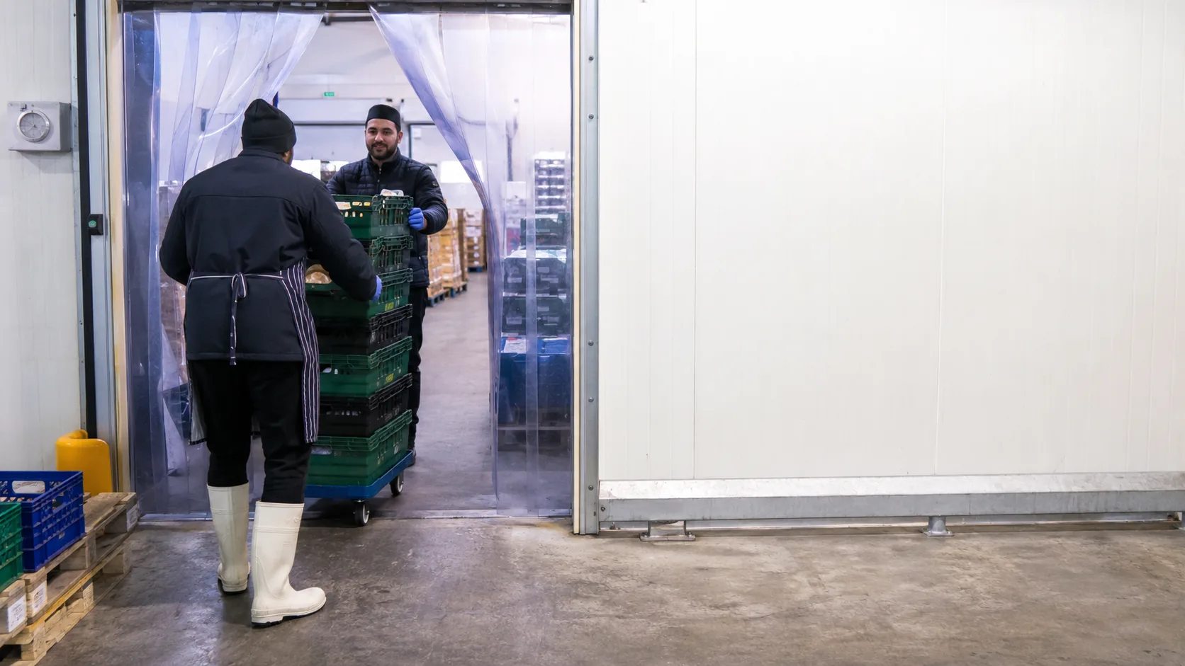 Customers use a busy British cold-room bay beneath clear directional light