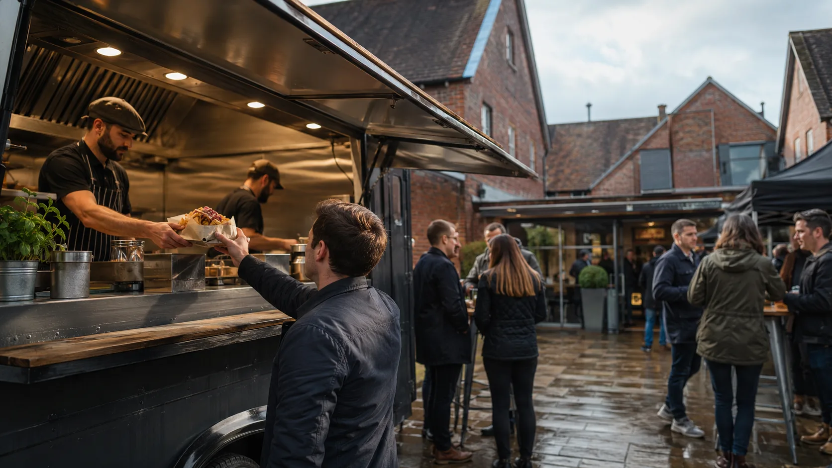 the UK food truck handing over street food in a brick courtyard