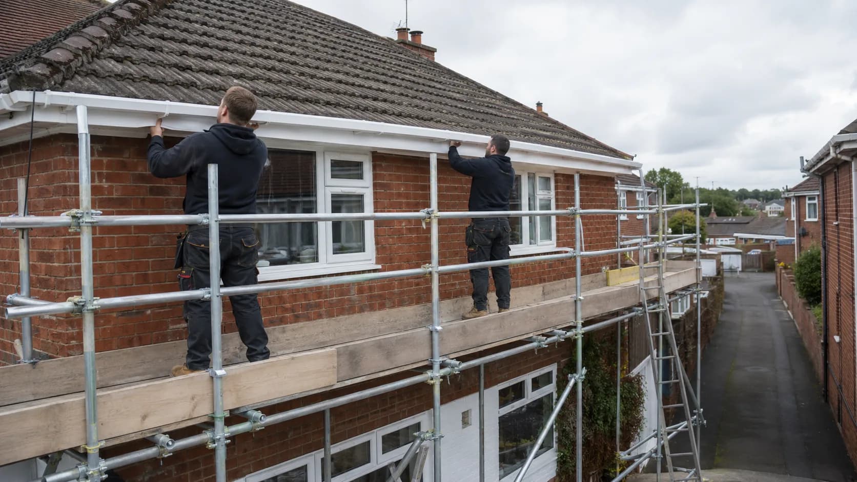 A fitter hanging a new gutter run in the UK