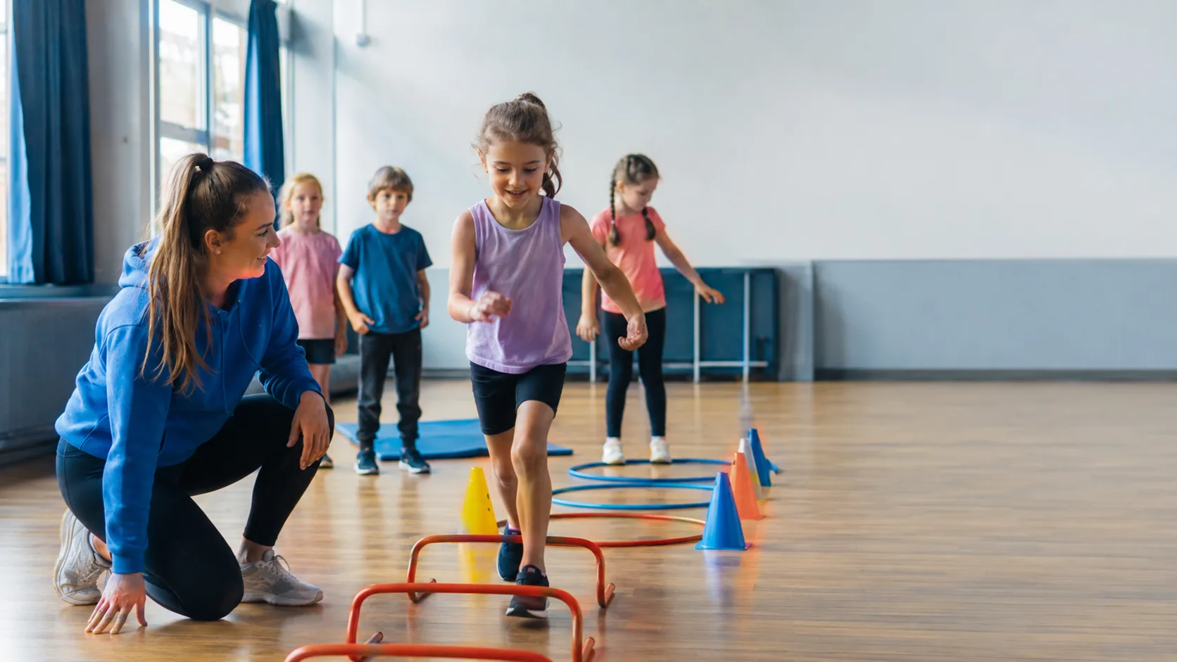 Staff leading an active holiday club session in a community hall in the UK