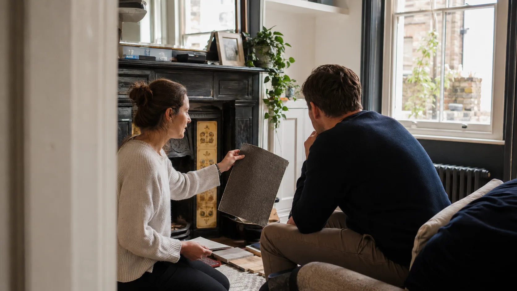 An interior designer compares material samples in a client home in the UK