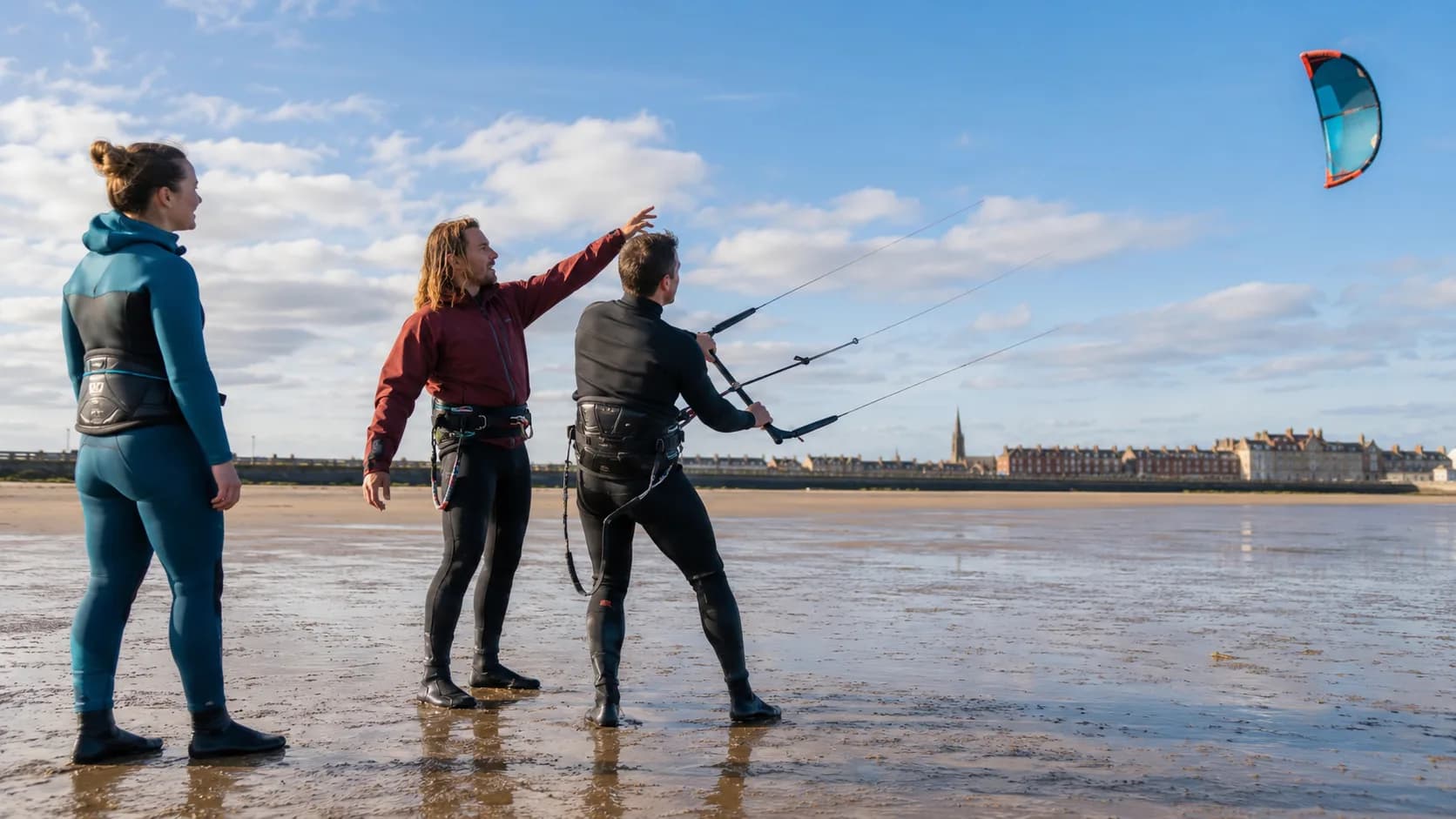 An kitesurf instructor teaches safe kite launching on a tidal beach in the UK