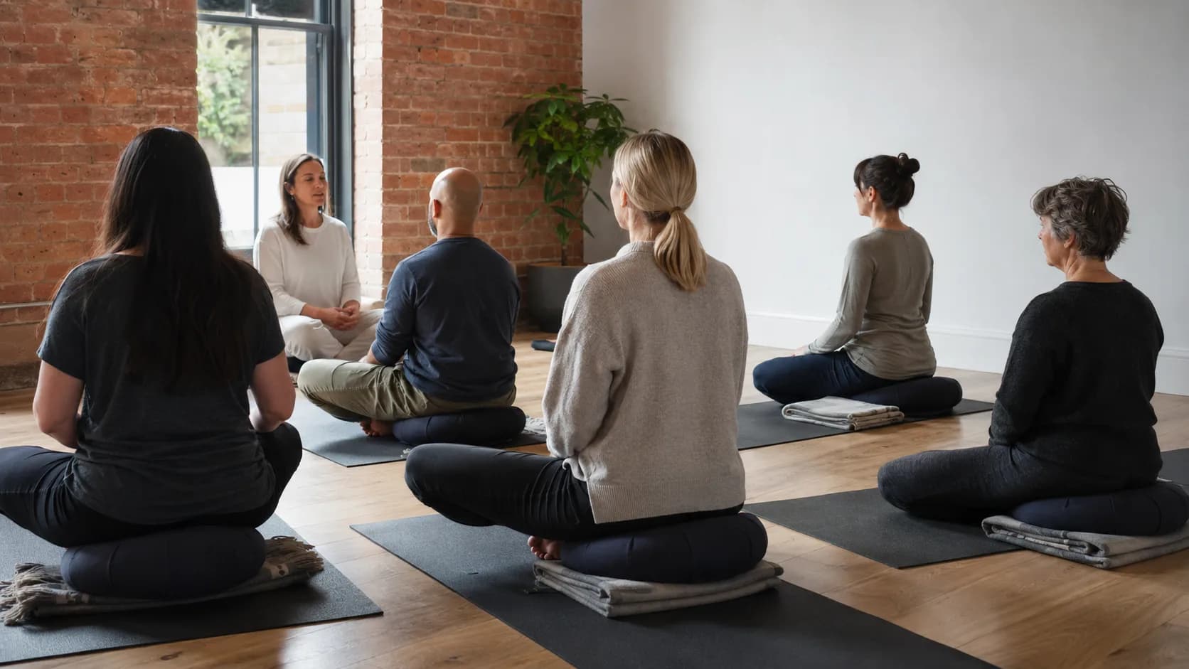 Teacher guiding a quiet meditation class in a studio in the UK