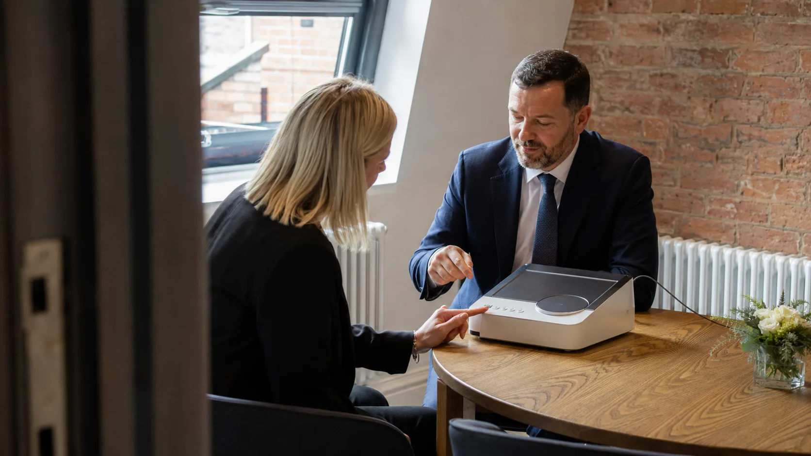 A product specialist demonstrates a device to a customer in the UK