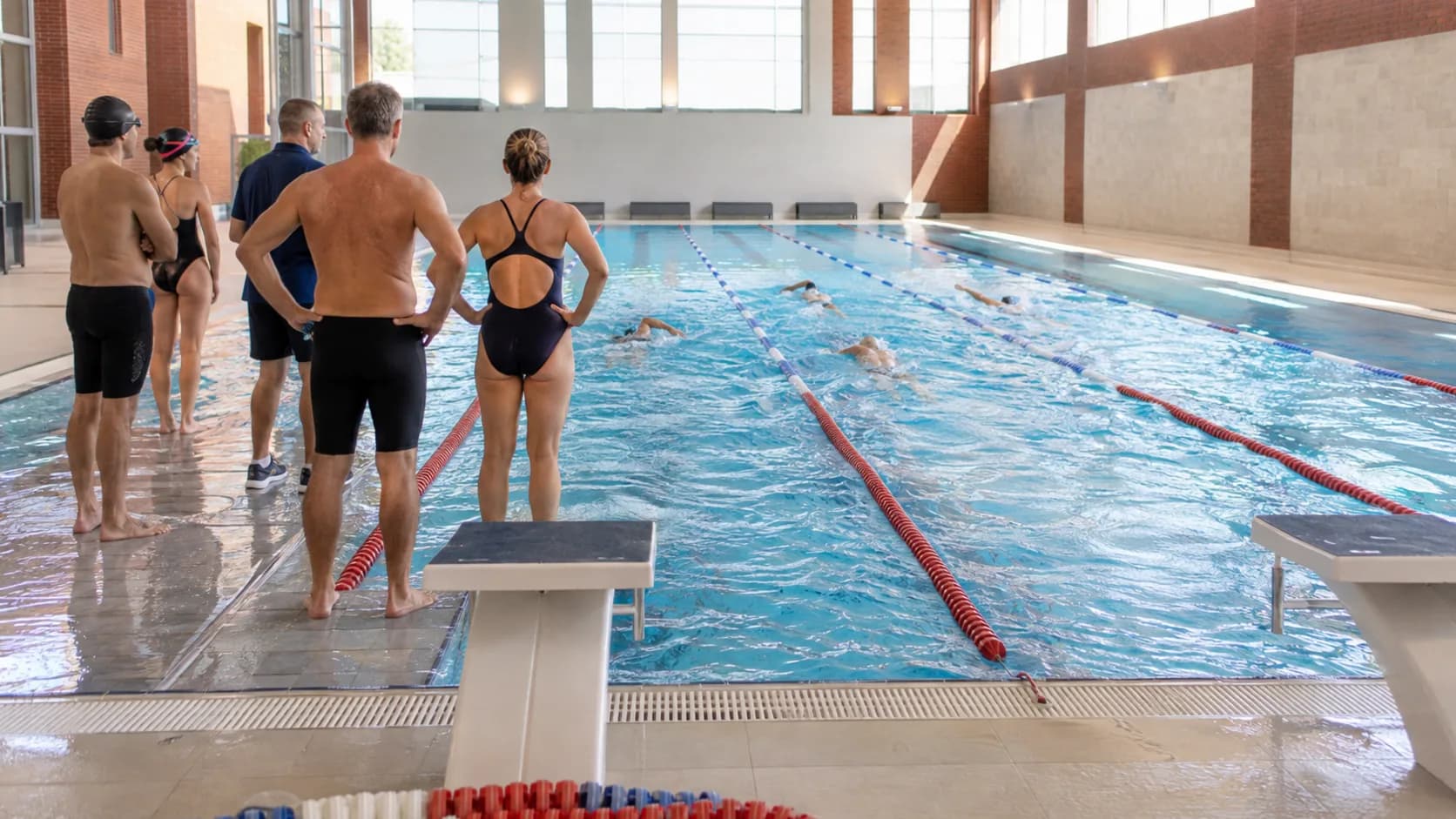 Masters swimmers train inside a bright brick leisure centre in the UK