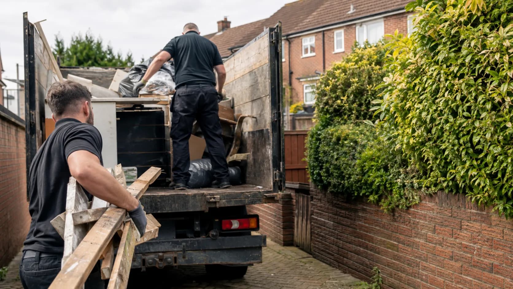 A crew loading a house clearance into a tipper truck in the UK