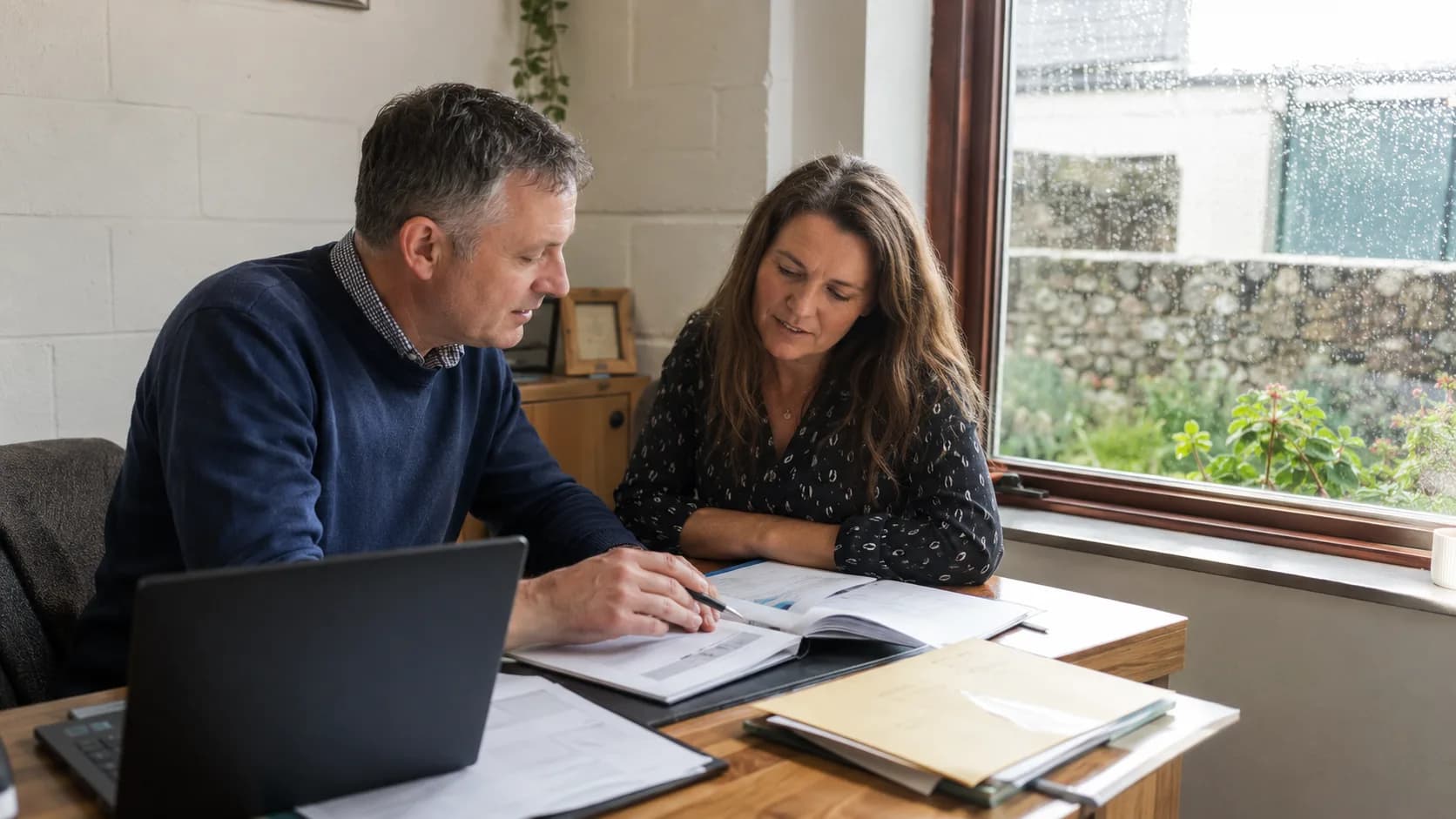 An accountant reviews financial papers with a small-business client in Ireland