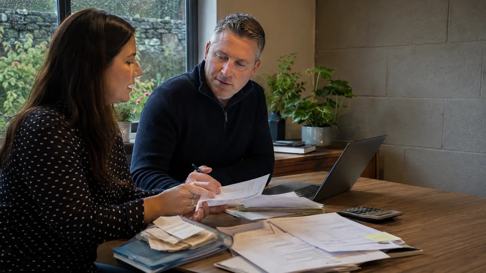 A bookkeeper works through receipts and records with a client in Ireland