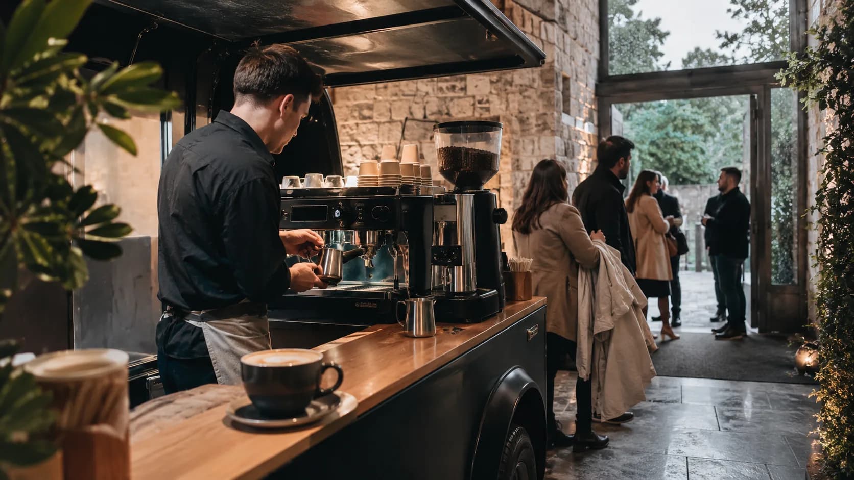 barista steaming milk inside a wet-weather hall entrance in Ireland
