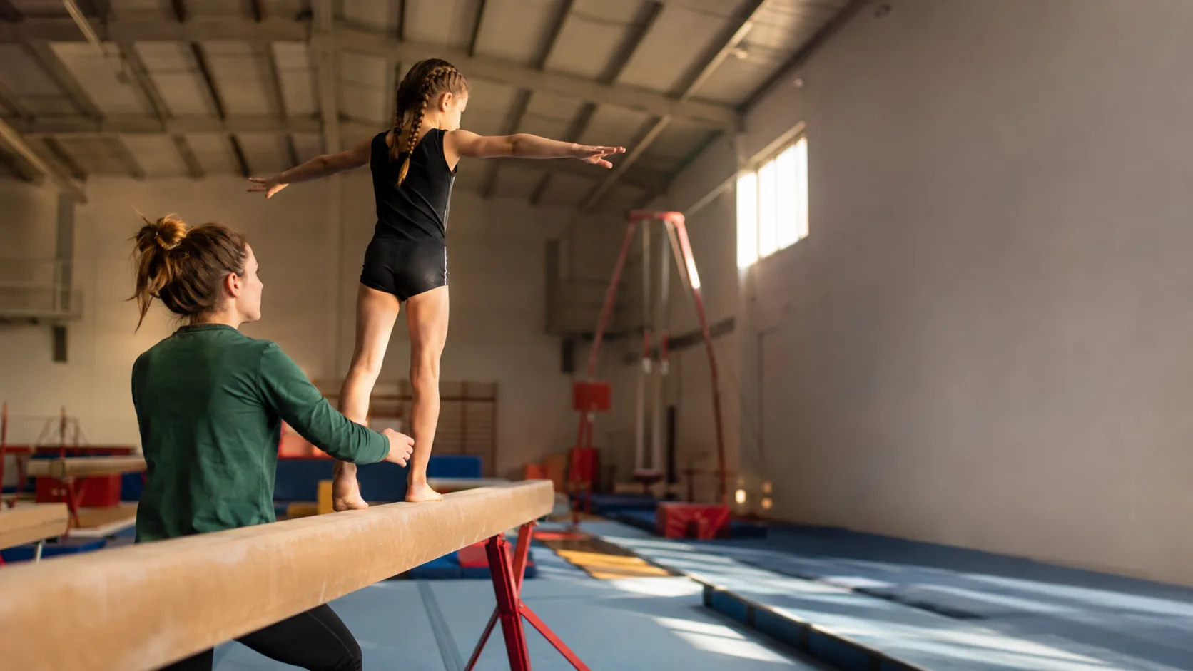 Coach supervising young gymnasts in a sports hall in Ireland