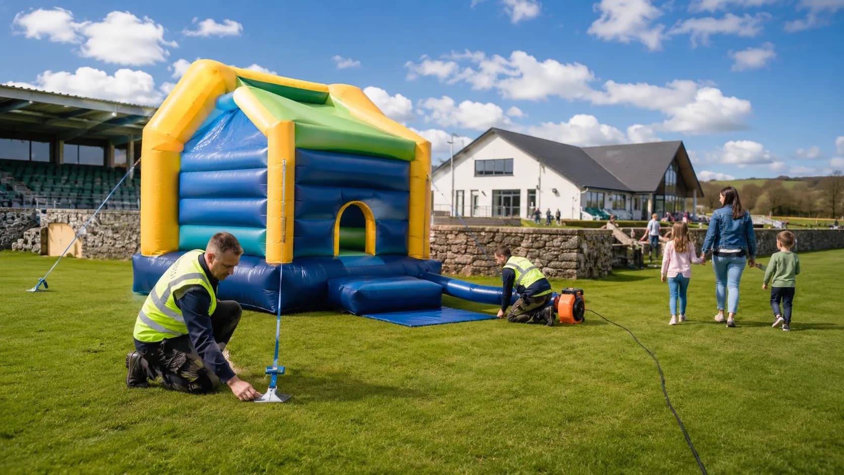 Crew inflating a bouncy castle beside an community hall in Ireland