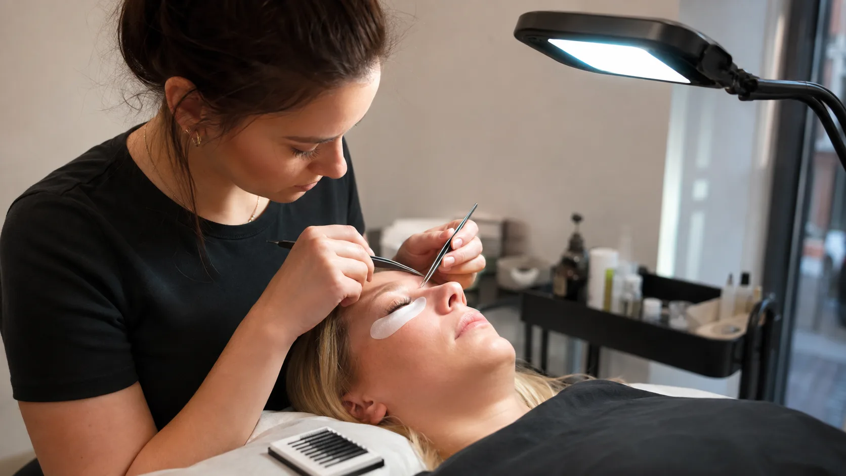 Lash artist applying extensions for a client inside a town-centre studio in Ireland