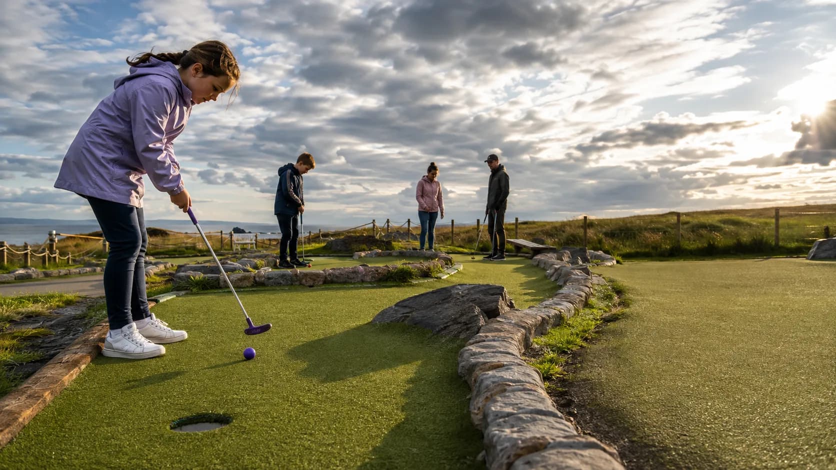 Families play a landscaped adventure golf course at an Irish coastal park