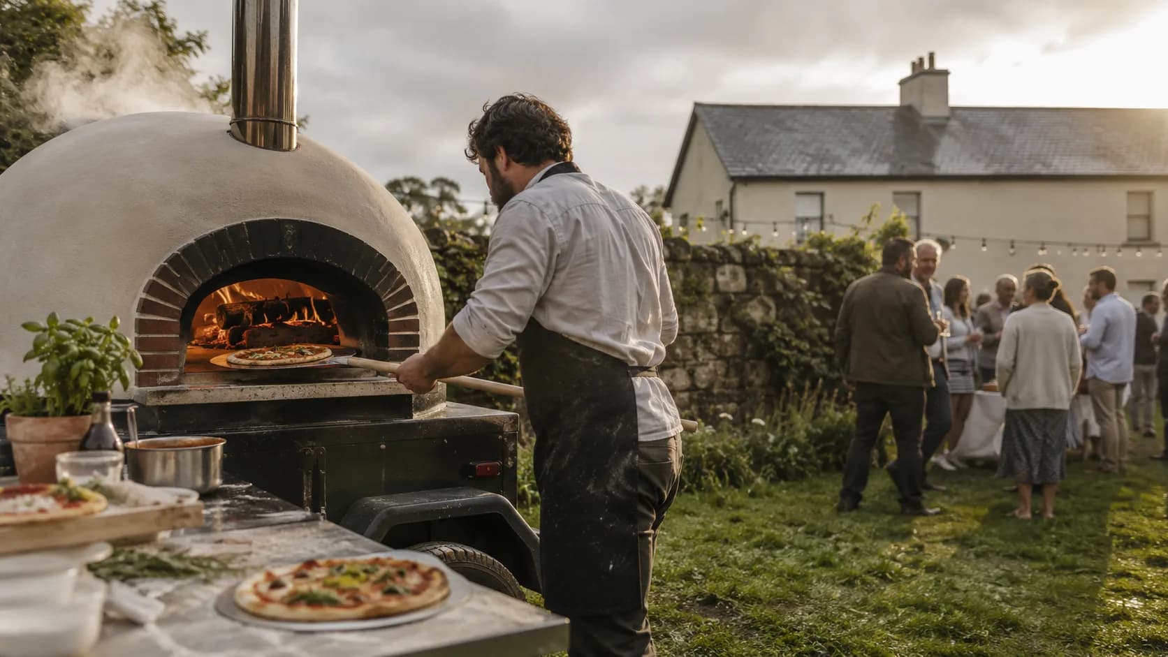 wood-fired pizza team stretching dough beside a green hall in Ireland