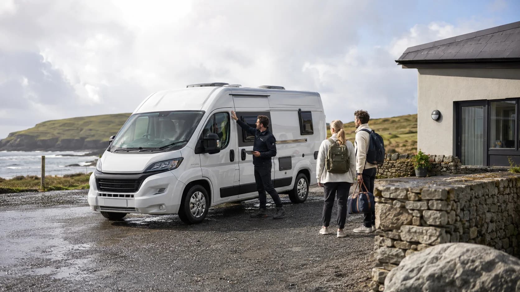 Travellers checking a motorhome beside the coast during a service handover in Ireland