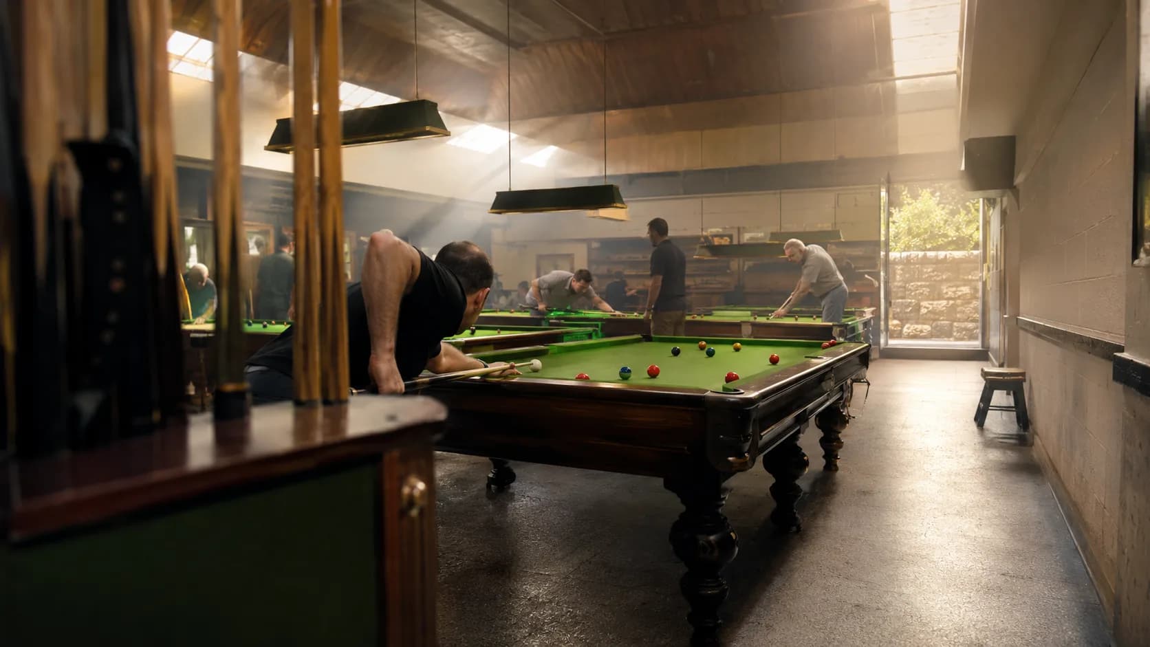 Players compete around green baize tables inside an Irish community club