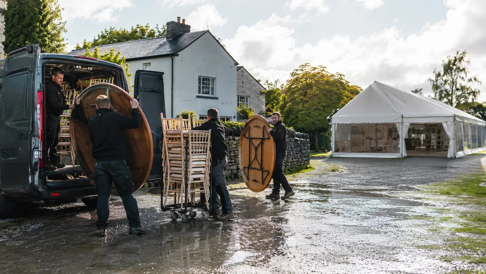 Operators unloading event furniture beside an marquee during a service handover in Ireland