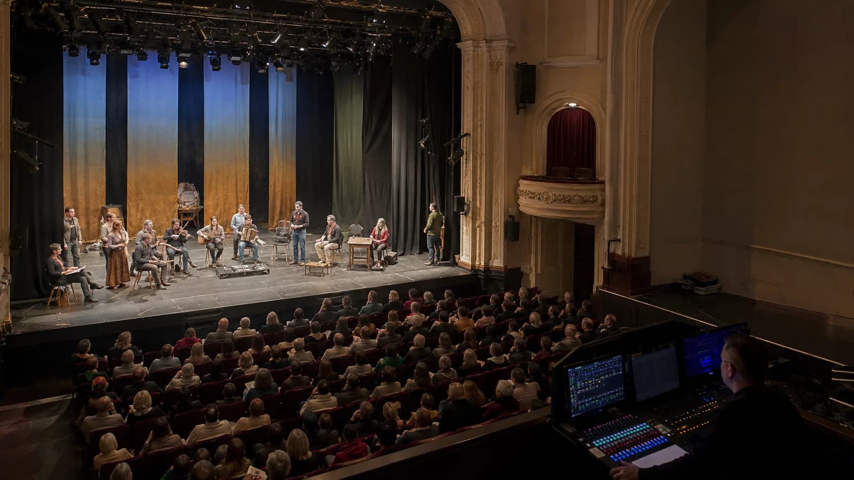 Crew and performers prepare an Irish city theatre at dusk